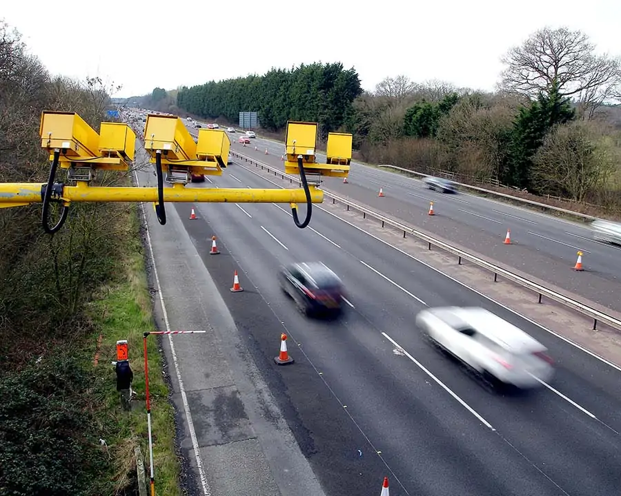 Speed cameras with cars speeding in the background.