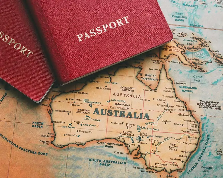 Geographical map of Australia with two red passport booklets on it.
