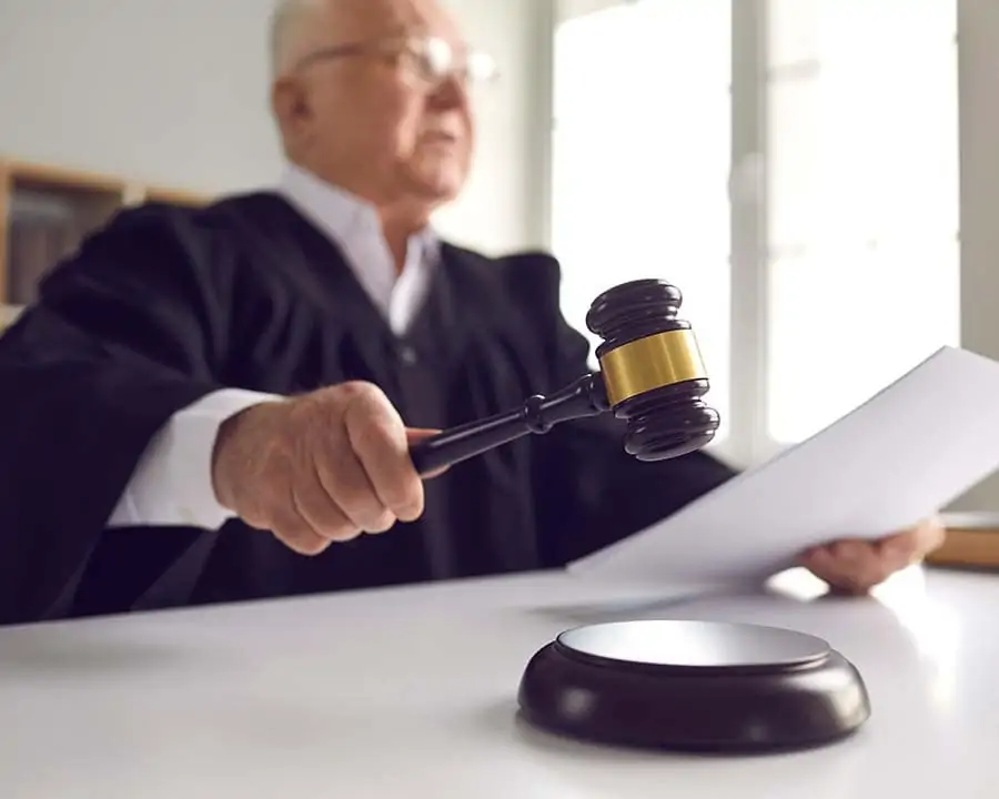 Judge hitting a gavel on the desk, imposing a sentence.
